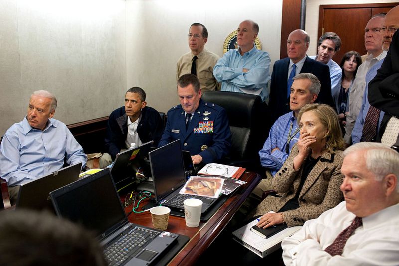 Blinken, standing in blue shirt in back of room, during the Osama Bin Laden raid